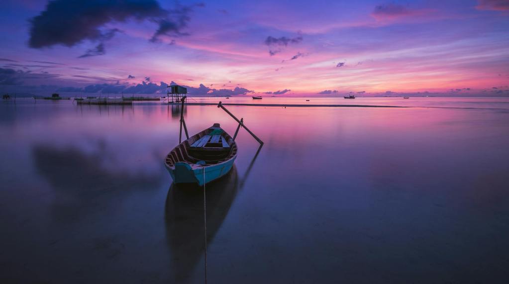green boat with oars on both side during golden hour panoramic photography